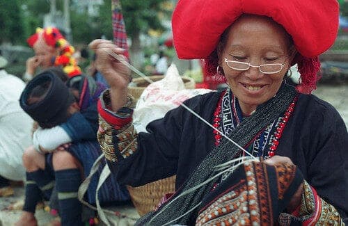Red Zao woman embroidering a shirt at the weekly market in Sapa. Vietnam