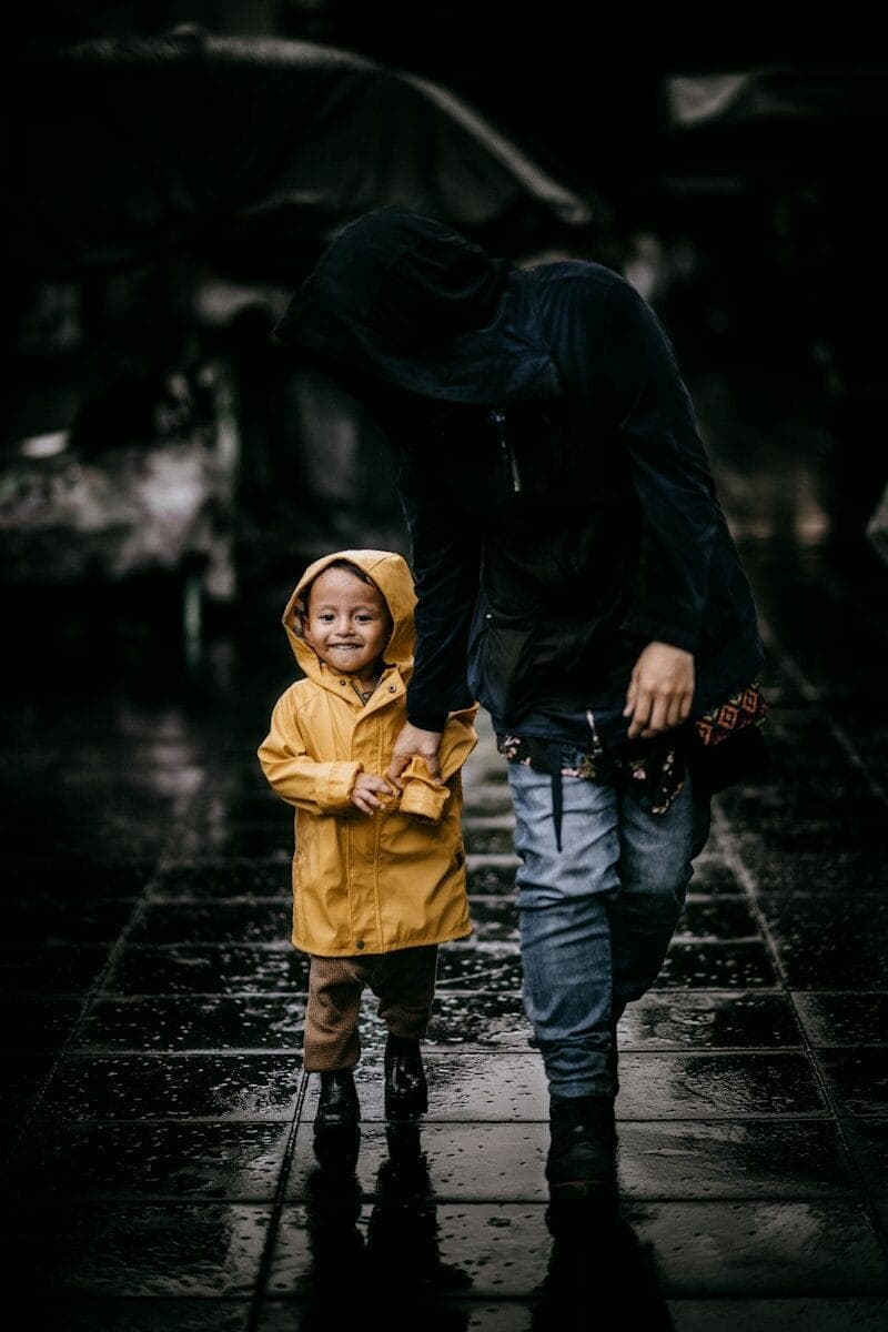 man in black jacket and child in yellow coat