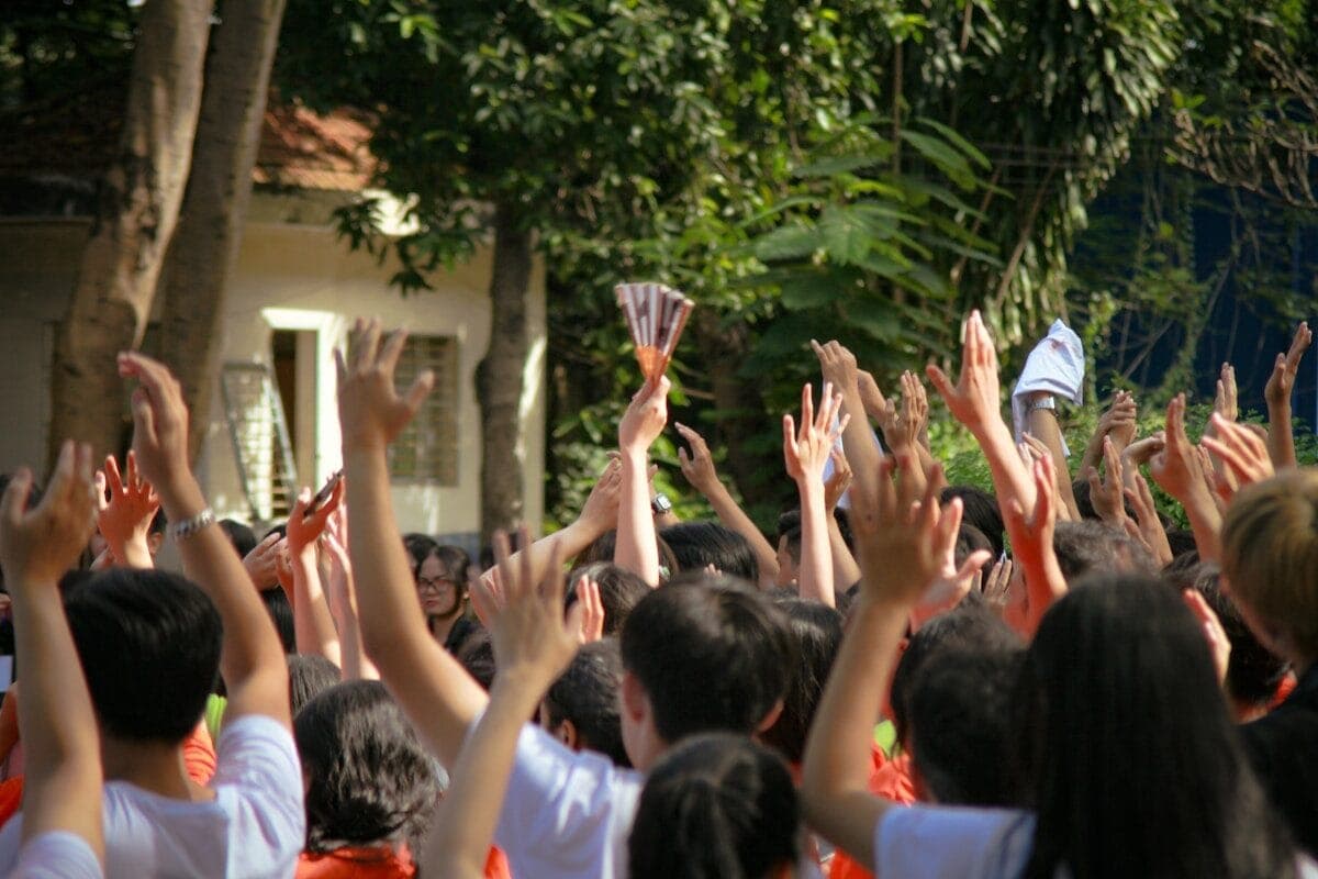 a group of people holding up their hands in the air