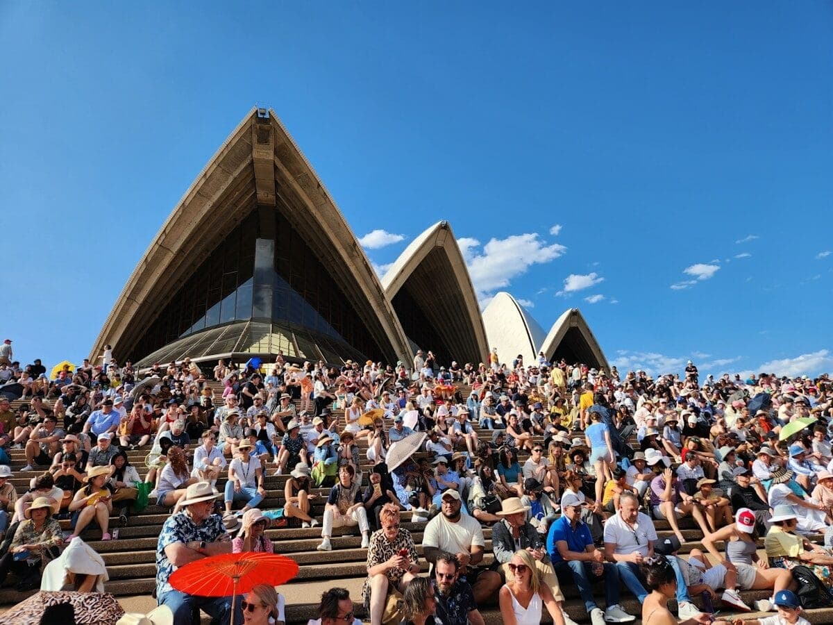 a large group of people sitting in front of a building