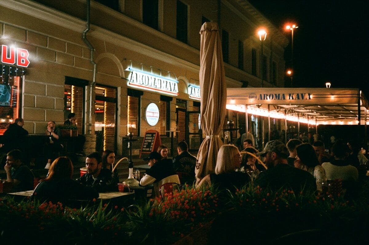 people sitting on chairs near brown wooden table during night time