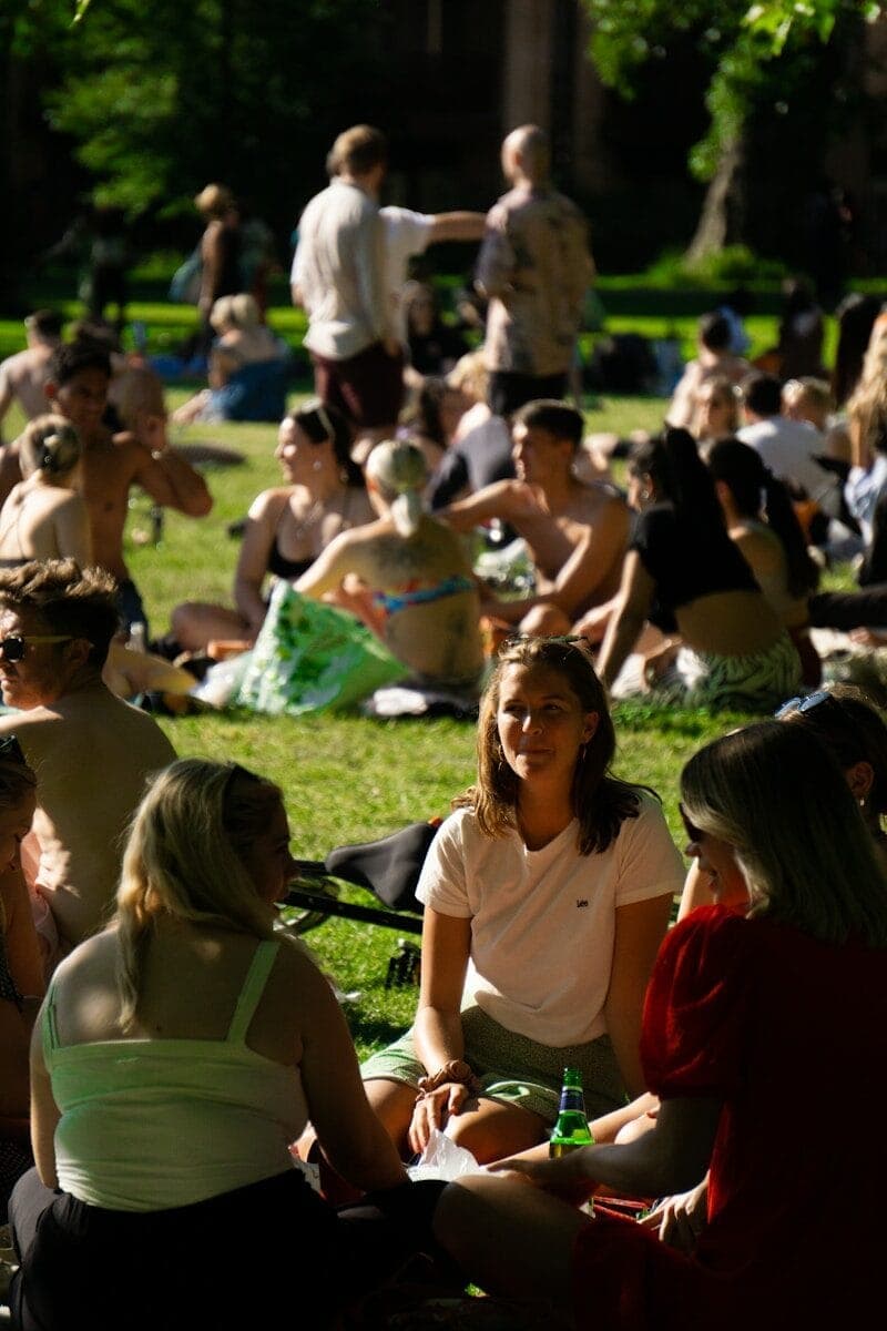 group of people sitting on green grass field during daytime