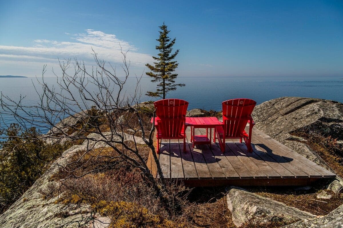two red chairs sitting on top of a wooden platform
