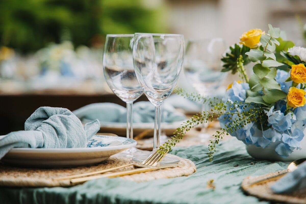 Table setting with floral arrangement and wine glasses.